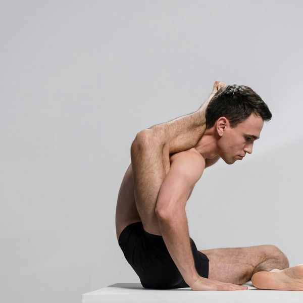 Man in a controlled stretching pose, showing flexibility and focus.